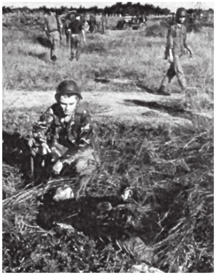  An airman checks out the body of a Viet Cong 'sapper' (commandos) killed during the battle