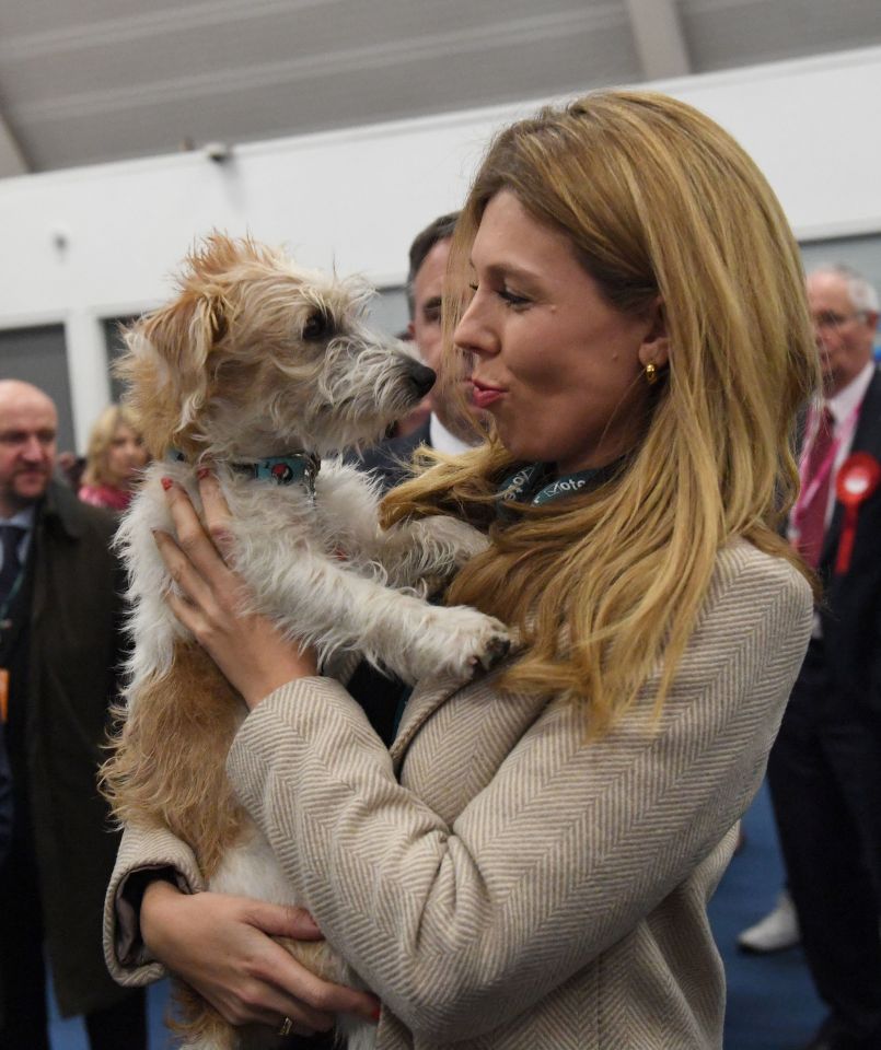  The PM's partner cuddles up to the couple's pet Dilyn on the day of the general election