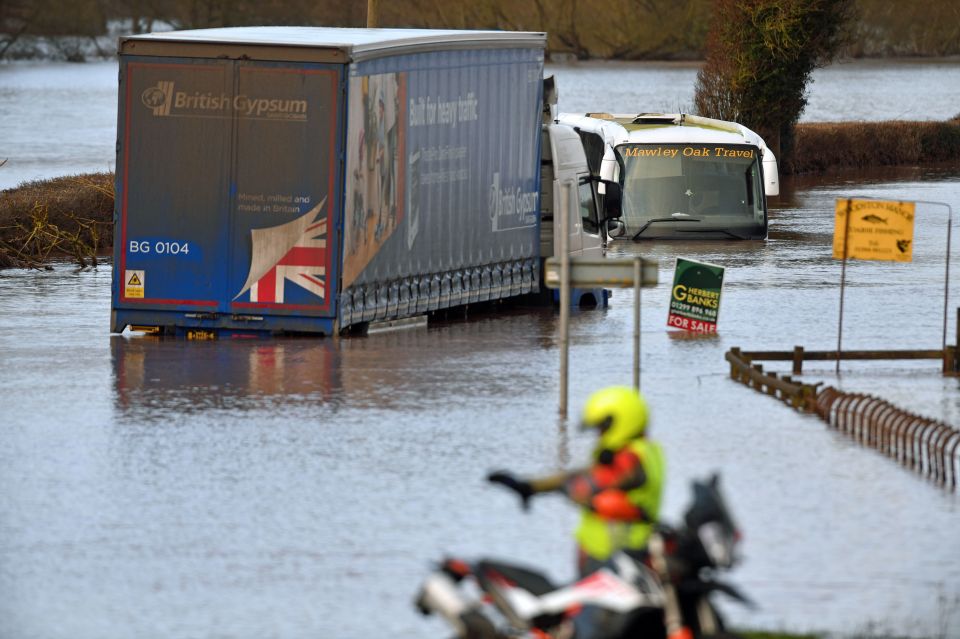  A lorry and a coach submerged in floodwater on the A443 near Lindridge, Worcestershire