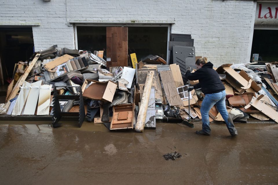  A member of staff clears up the wreckage outside a flooring shop in Nantgarw, South Wales