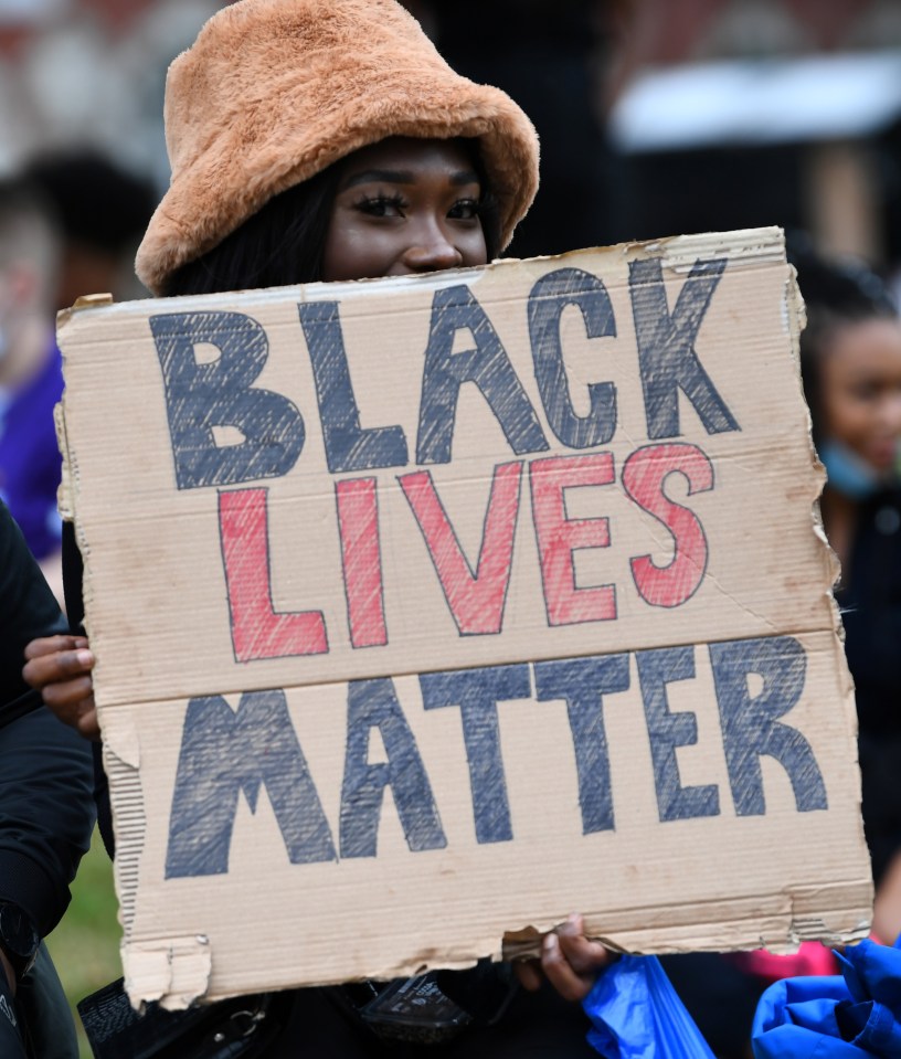 A woman holds a 'Black Lives Matter' sign during today's demonstrations