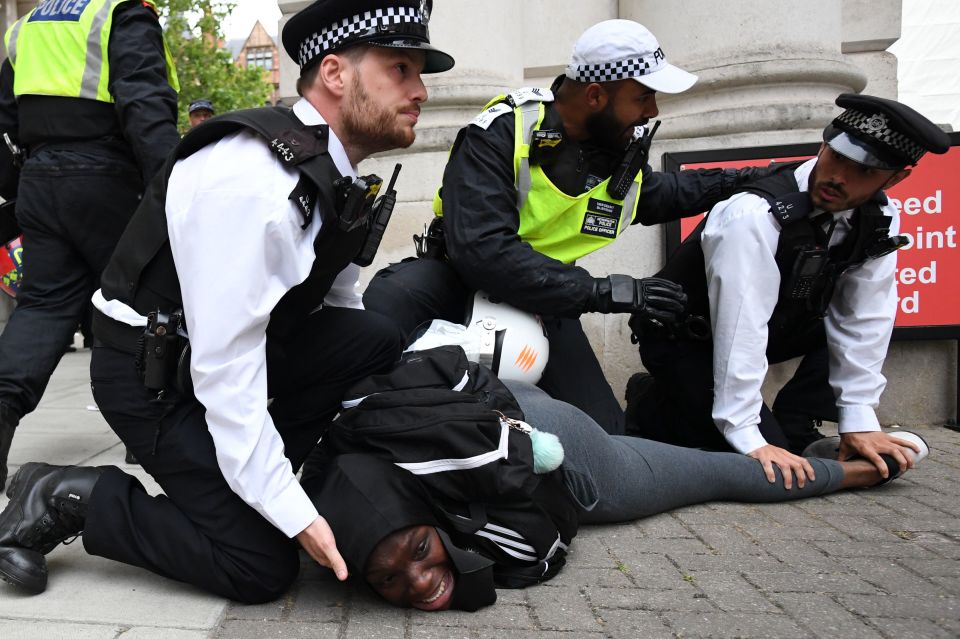  A man was pictured being pinned to the ground by police