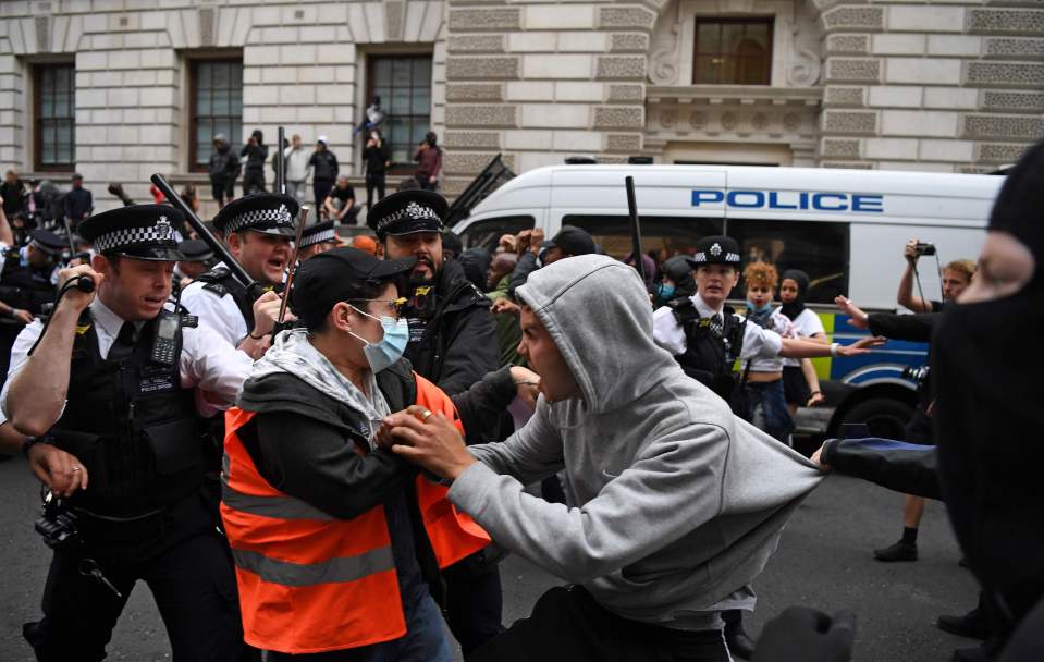  A man in a grey hoodie was pictured grasping a man wearing a high-vis jacket