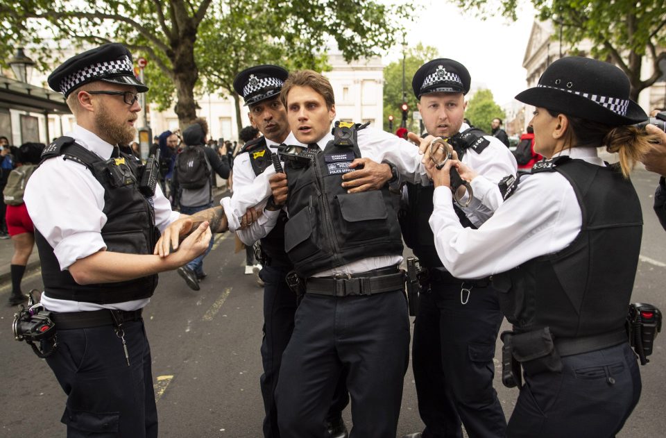  A policeman staggers after he was reportedly hit in the head by a missile