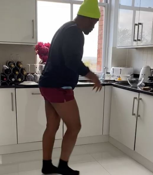  His kitchen features white cupboards and contrasting black work tops