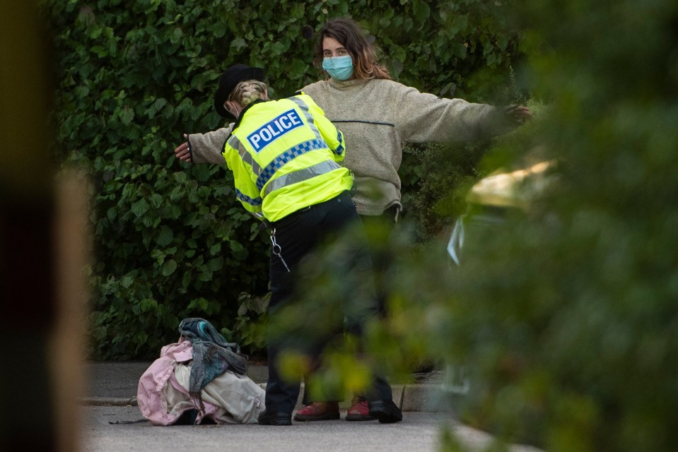 A police officer searches a protester