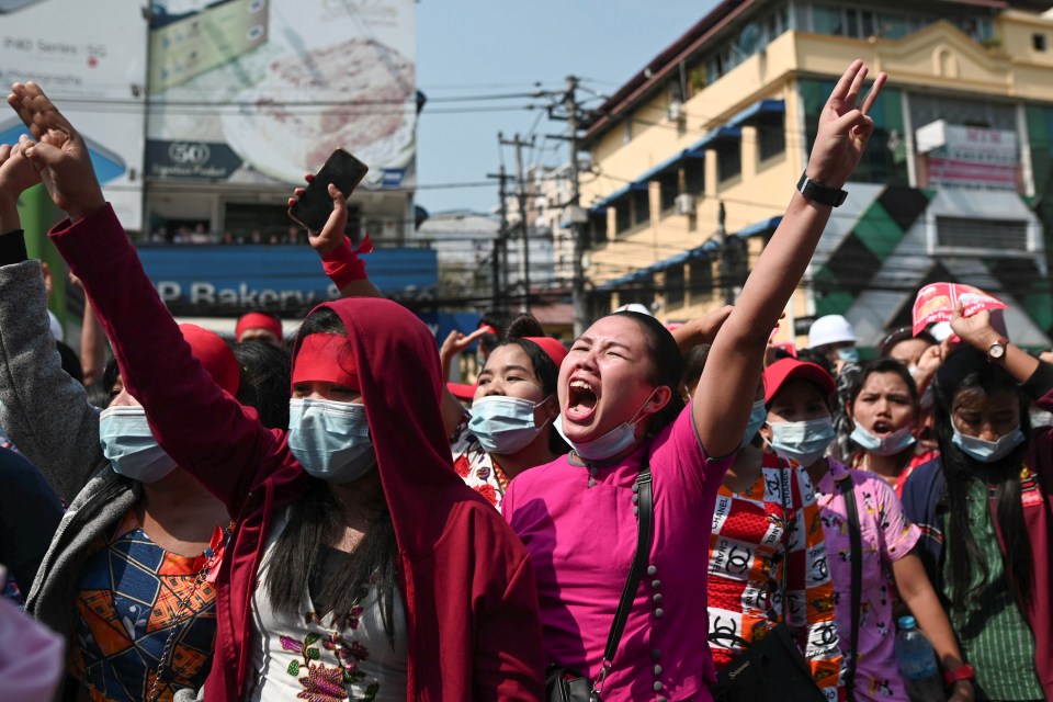 Demonstrators show the three-finger salute to protest against the military coup and demand the release of elected leader Aung San Suu Kyi