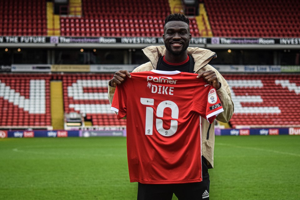Dike holds aloft his No10 Barnsley shirt when he was unveiled in February