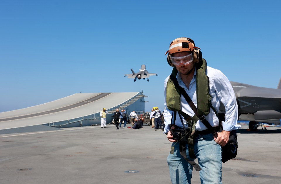 The Sun cheered Navy and RAF jets as they roared off the flight deck of HMS Queen Elizabeth to target IS in Iraq (pictured Sun Defence Editor Jerome Starkey)