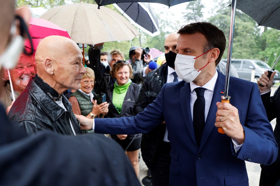 Macron speaks to a member of the public at a polling station in Le Touquet earlier today