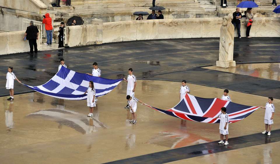 a group of children are holding a british flag and a greek flag
