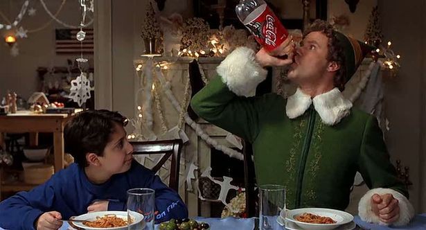 Buddy the Elf drinking Coca-Cola at a Christmas dinner.