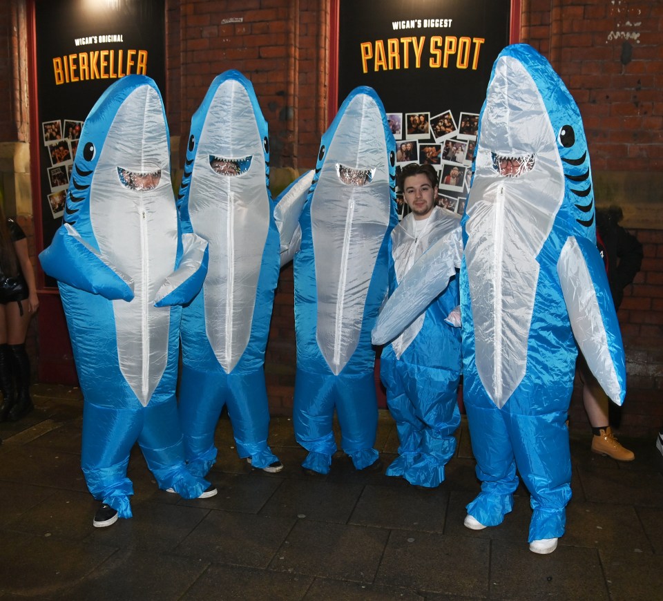 A group of lads don some inflatable shark outfits in King's Street, Wigan