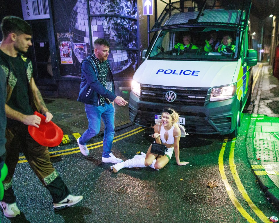 People in fancy dress are seen outside clubs on King Street in Wigan