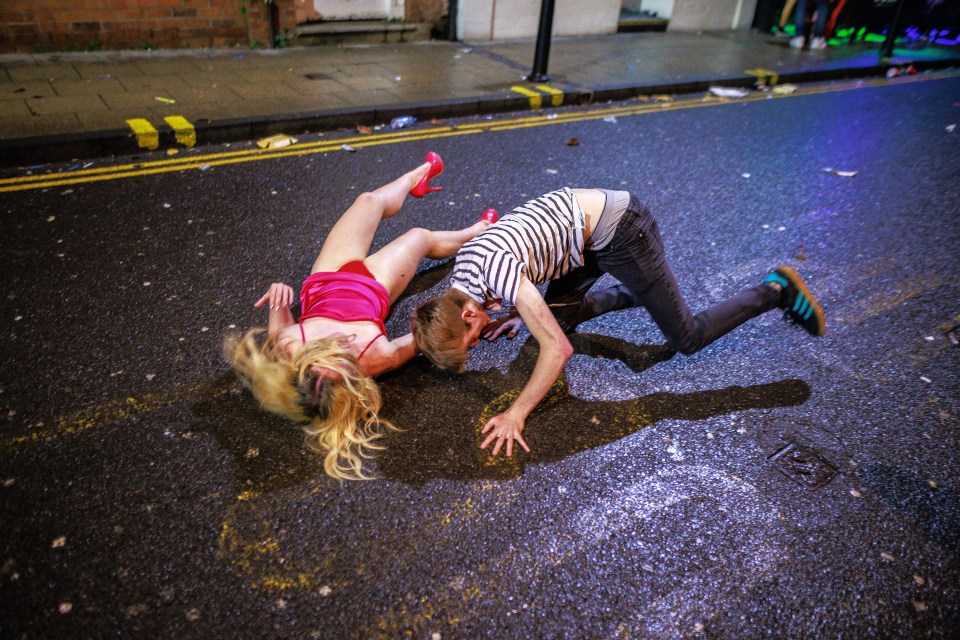 A couple topple in the road after a man trips whilst carrying a woman on his back
