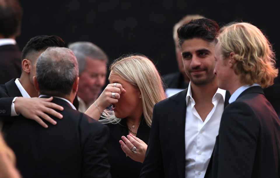 Brooke Warne wiping away tears as she welcomed mourners into the MCG