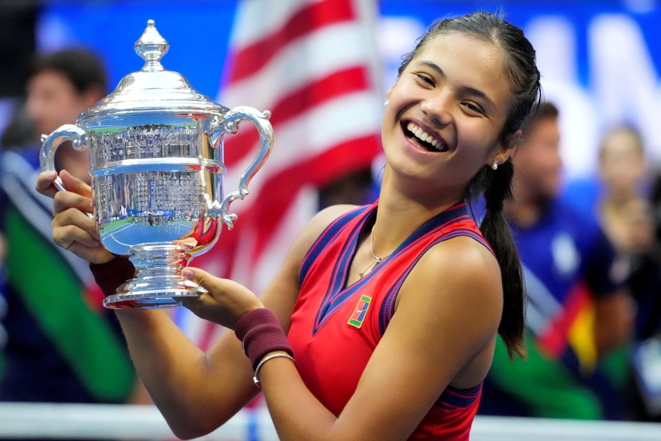 a woman holding a trophy that says us open on it