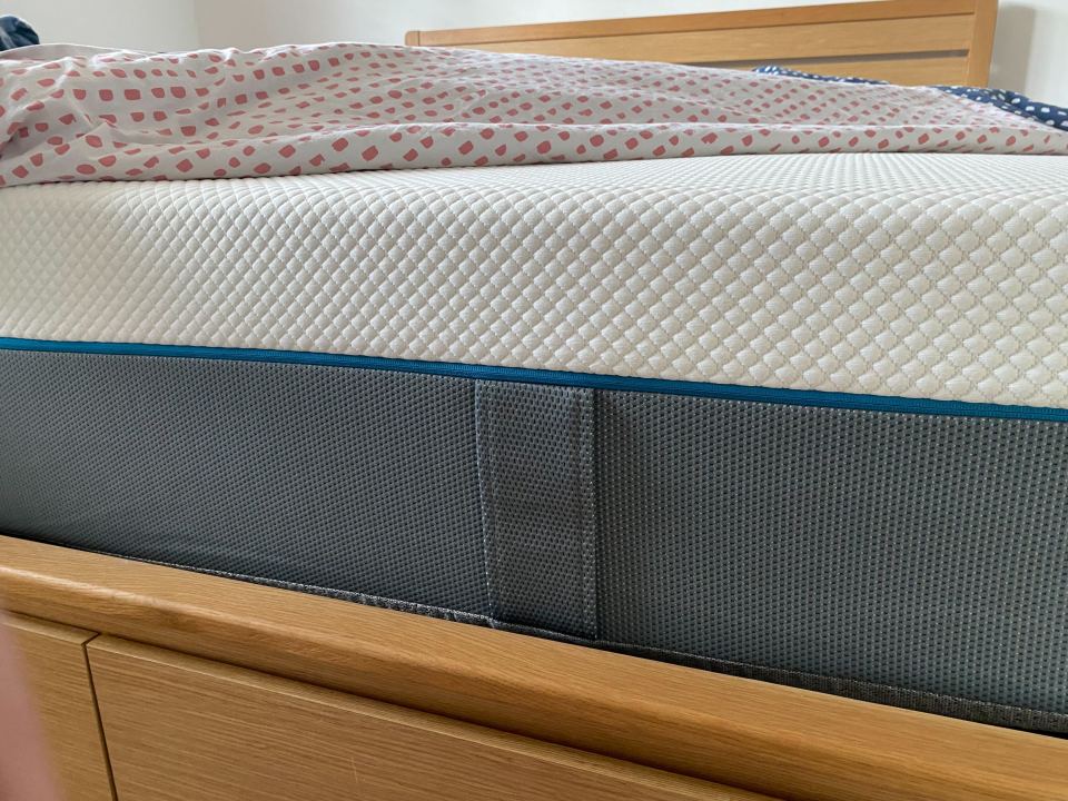 a bed with a mattress and a polka dot comforter on it