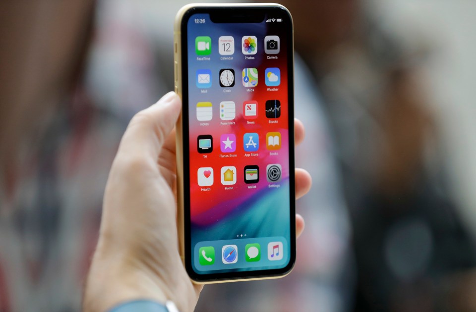 A hand holding an iPhone XR.