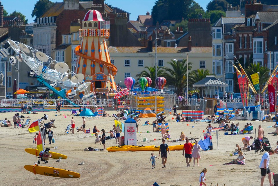 Beachgoers enjoy  the scorching hot afternoon sunshine at the seaside resort of Weymouth in Dorset