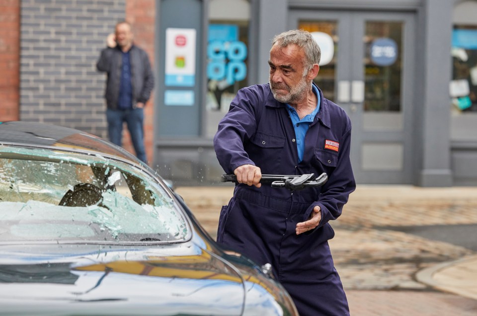He picks up a wrench and smashes a car