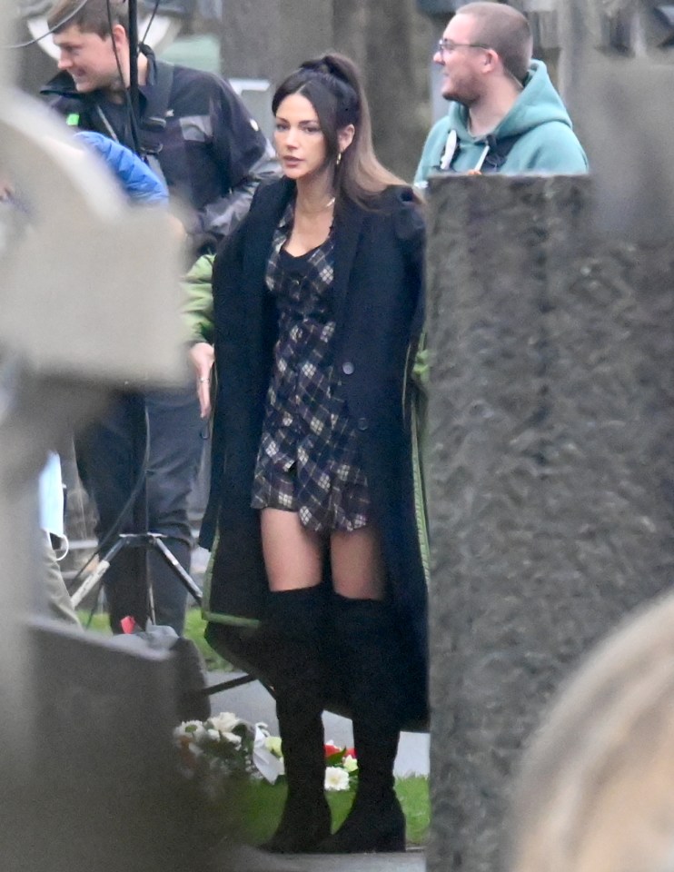 The actress sported a trendy check mini-dress and thigh high-boots for new scenes on the Sky drama