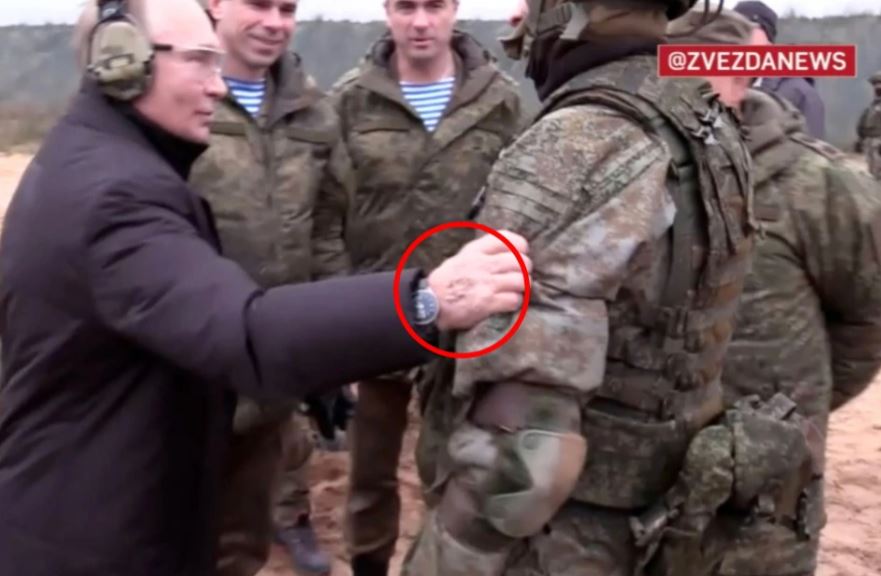 Vladimir Putin touching a soldier's shoulder.