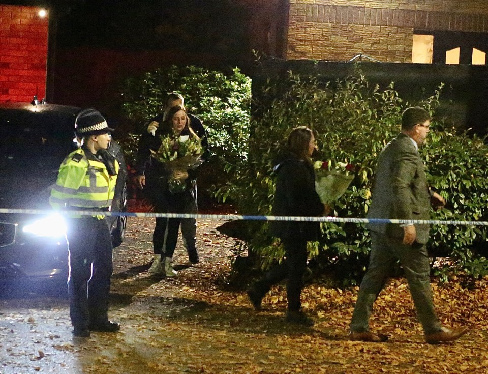 Family members arrive at the scene to lay floral tributes