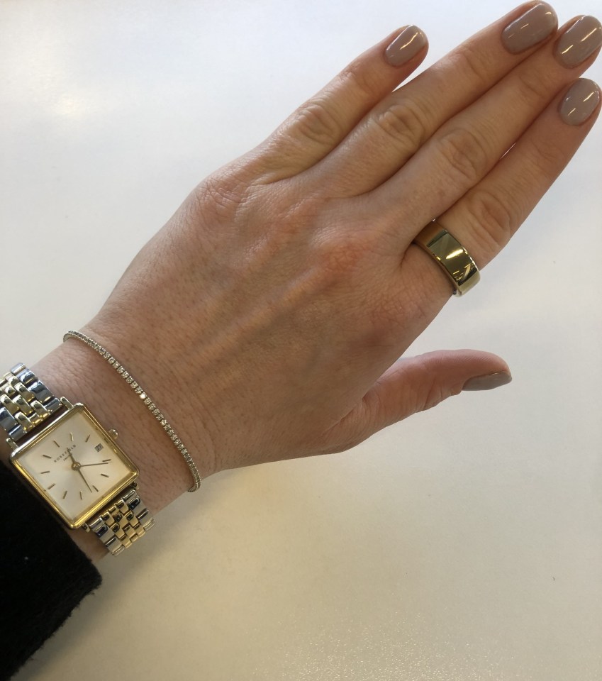 a woman wearing a gold watch and a gold ring