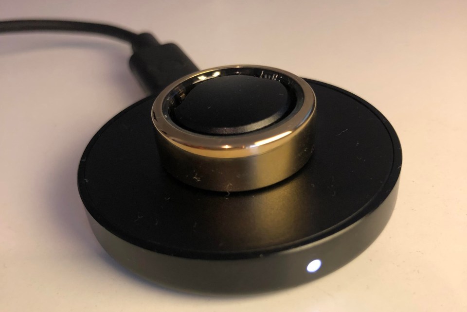 a gold ring is sitting on top of a black charger