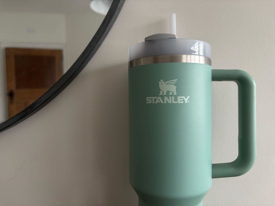 A teal Stanley mug with a straw.