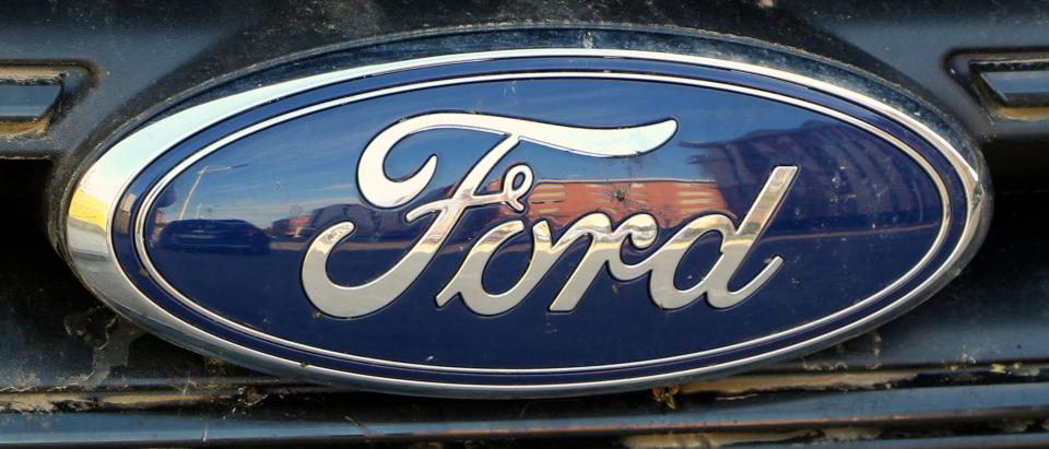 2F7MNYD Oval Ford chrome and blue car badge in natural sunlight