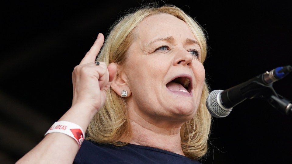 a woman singing into a microphone wearing a wristband that says all areas