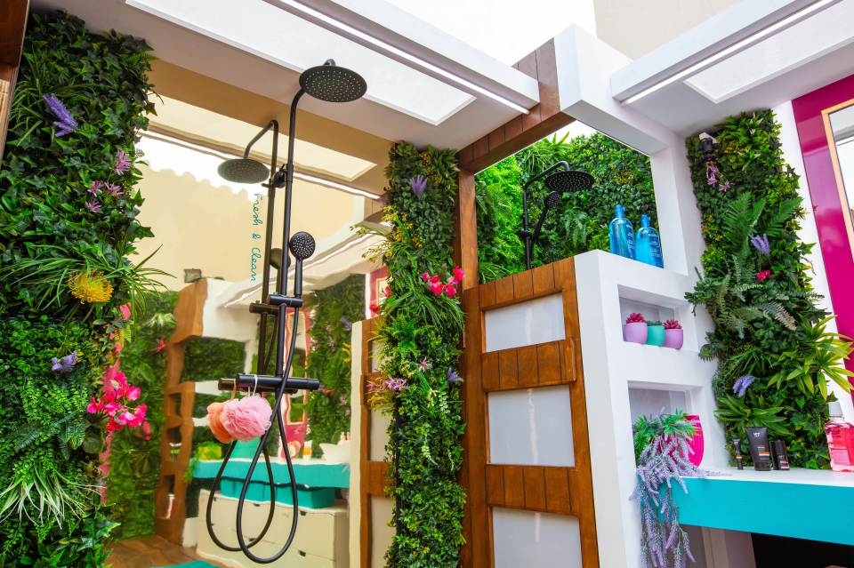 The shower is surrounded by lush green plants