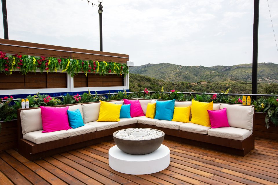 The white sofa is focused around the firepit