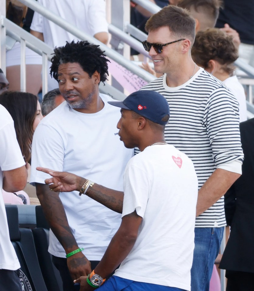 a man wearing a white shirt with a heart on it is talking to another man