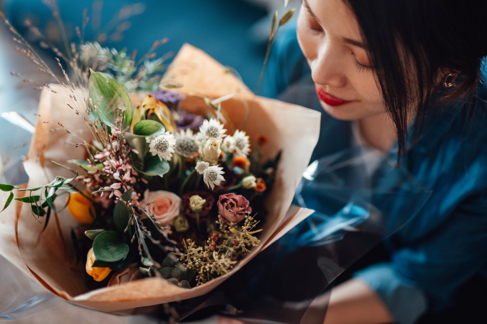 Aerial view of young woman receiving flower bouquet delivery on Valentines day. Online dating concept. Long distance relationship concept. Remote love.