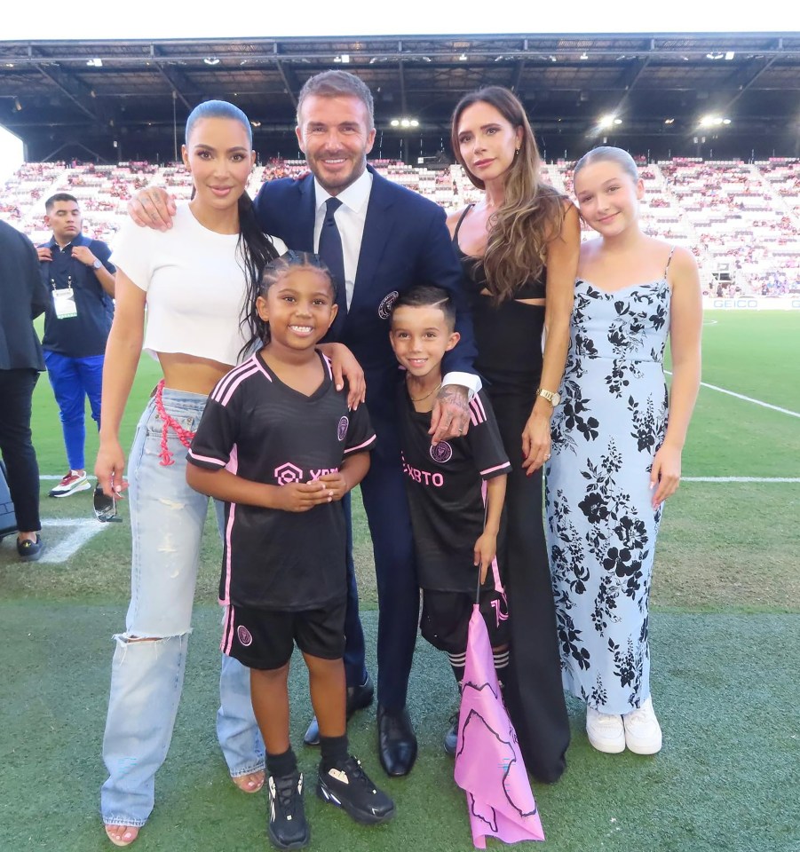 a family posing for a picture on a soccer field with a boy wearing a jersey that says ' santos '