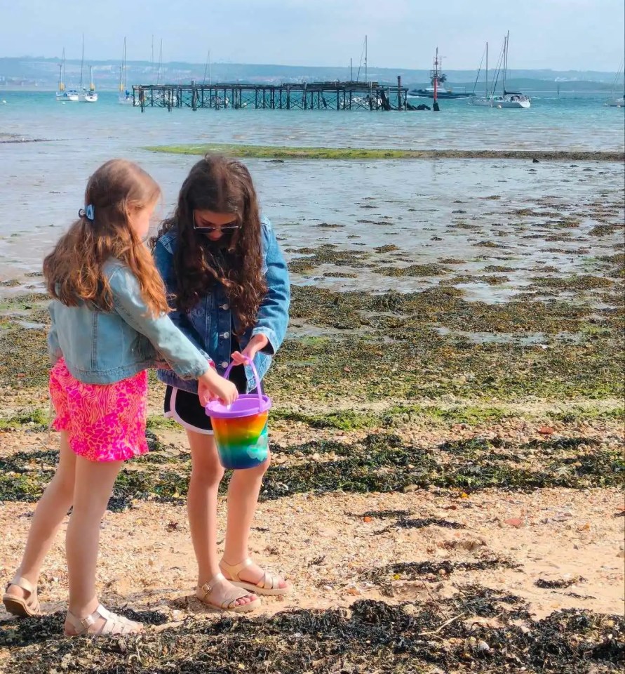 Amelie and Isabelle have buckets of fun collecting shells on the beach