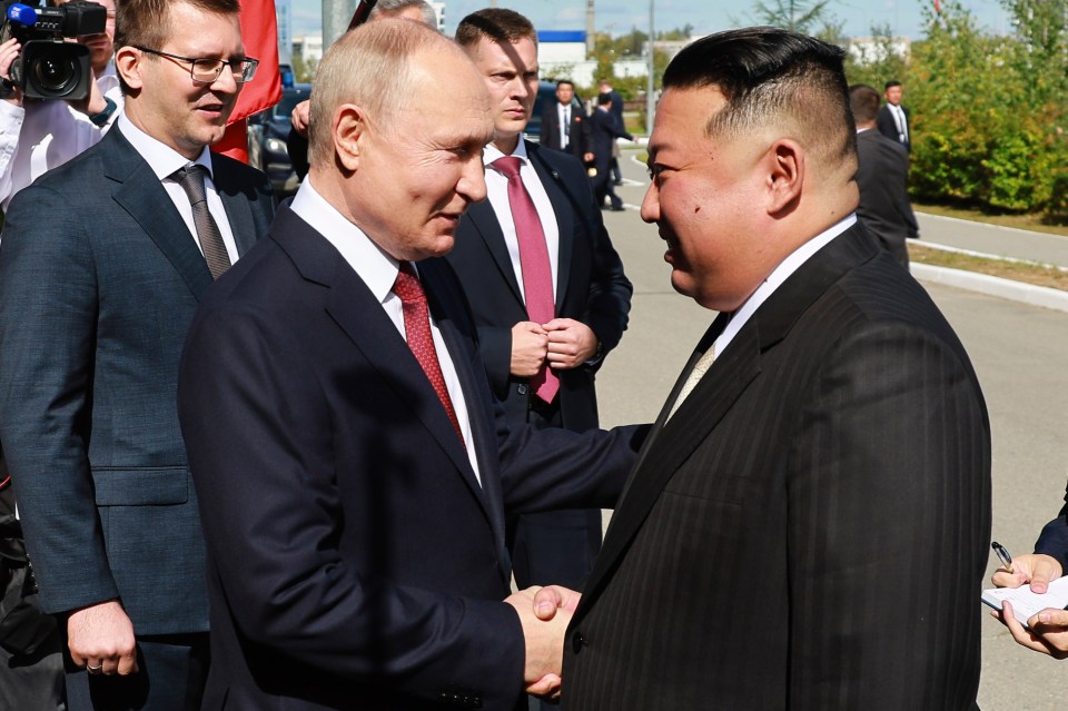 Putin and North Korea’s leader Kim Jong Un shake hands as they meet in Tsiolkovsky