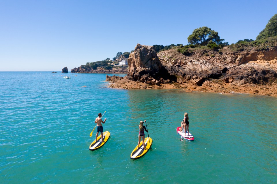 Three people paddleboarding in St. Brelade's Bay.