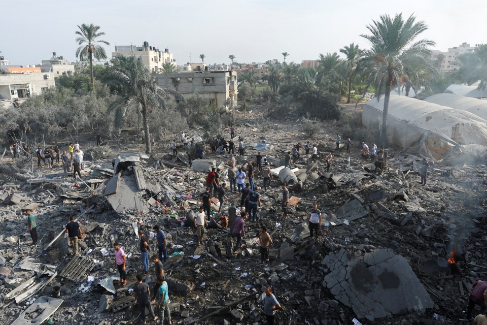 Palestinians gather on rubble in the aftermath of Israeli strikes