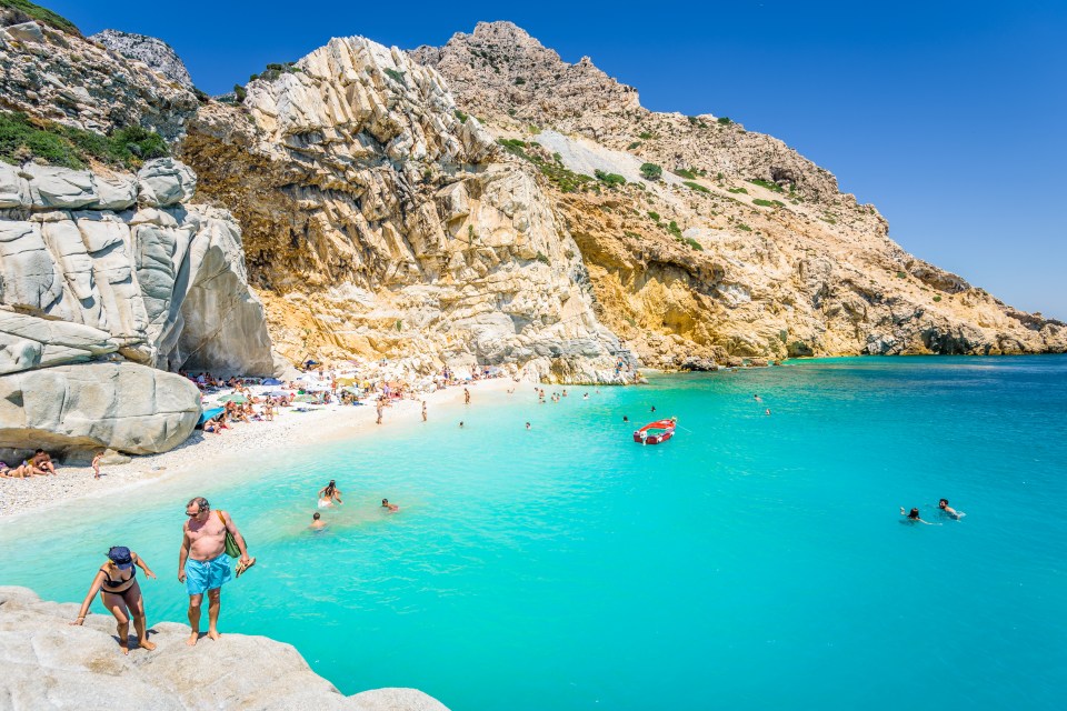 Ikaria Island, Seychelles Beach, Sporades/ Greece - 08 01 2017: Beautiful sunny coast view to a amazing paradise holiday bay with crystal clear blue water sandy beach for sunbathing swimming relaxing; Shutterstock ID 1049193098; purchase_order: -; job: -; client: -; other: -