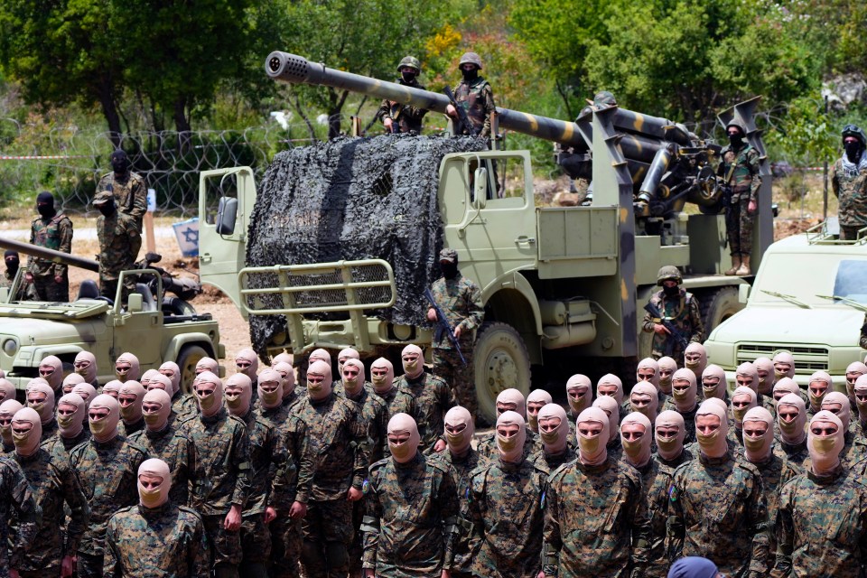 a group of soldiers wearing masks stand in front of a military vehicle