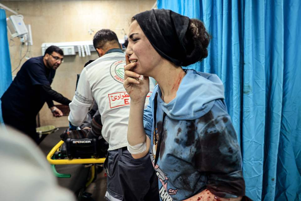 An injured Palestinian woman reacts as she stands in the emergency room of the al-Aqsa Hospital on Wednesday