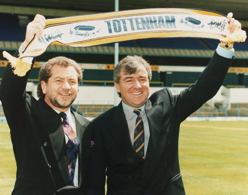 two men are holding up a tottenham scarf
