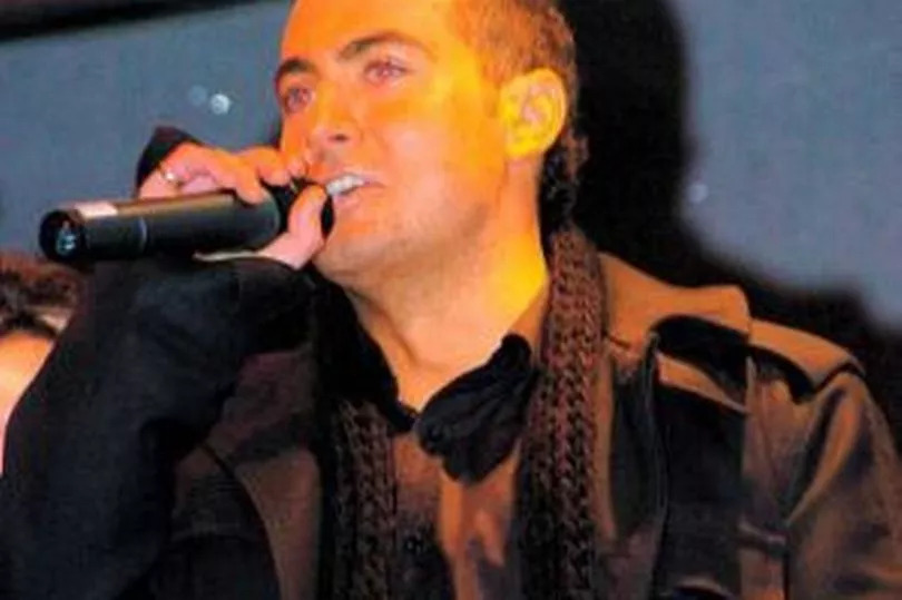 Paul Danan performing on stage.