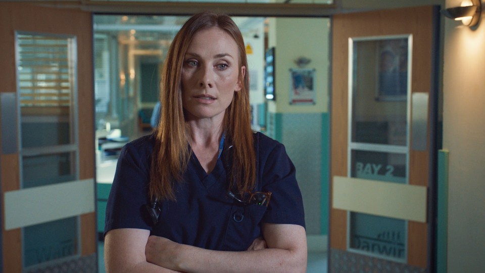 Jac Naylor, a doctor from Holby City, stands with her arms crossed.