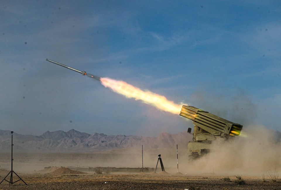 a rocket is being launched in the desert with mountains in the background