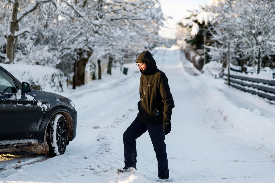ARDGAY, SCOTLAND - JANUARY 18: Members of the public make their way through snow after the Met Office issued weather alerts for snow as low temperatures continue across the north of the country on January 18, 2024 in Ardgay, Scotland. The Met Office issued a rare amber snow warning for northwest Scotland as the UK experienced near-record low temperatures on Tuesday night, with the mercury dropping to -14C. (Photo by Jeff J Mitchell/Getty Images)